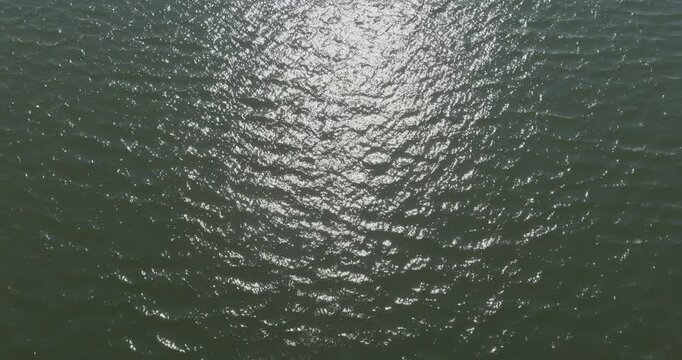 Aerial view of a body of water with sunlight reflecting off its surface in summer, Pentala, Espoo, Finland.