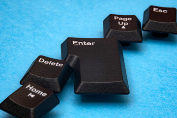 Abstract representation features scattered keyboard keys. Keys are including Enter and Delete, resting upon blue surface. Emphasizing foundational technology and vintage hardware. Selective focus.