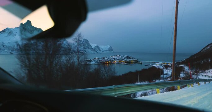 Hus&oslash;y im Winter zur blauen Stunde mit Blick in den Hafen, schneebedeckte H&auml;user und Boote im ruhigen Fjord, kalte Abendstimmung und klares arktisches Licht in Nordnorwegen