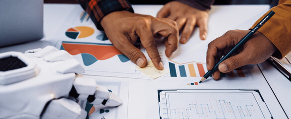 Two individuals collaborating on data analysis with visual graphics on a desk, showcasing modern...