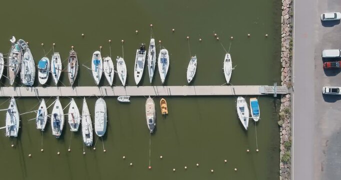 Aerial view of Suomenoja Marina, featuring numerous sailboats and yachts docked along a pier in summer, Espoo, Finland.
