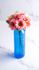 Pink flowers in a blue bottle, on a white marble surface, soft lighting