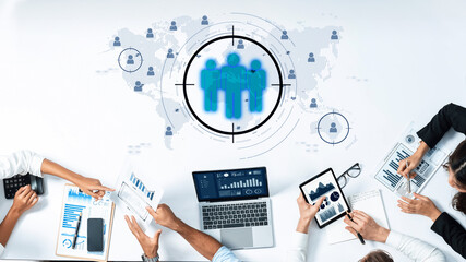 A diverse business team engages in collaboration around digital tools to analyze data and create marketing strategies with a focus on global connectivity and operations. Trope