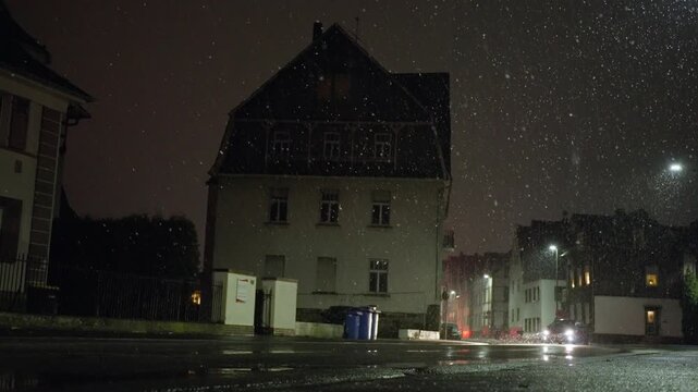 Vehicle Beams Pierce Snowy Night, Automobile Headlights Penetrate Deep Snow As They Move Silently Through Darkness, Headlights From Car Cut Through Thick Snow And Spray Onto Wet Pavement Beneath