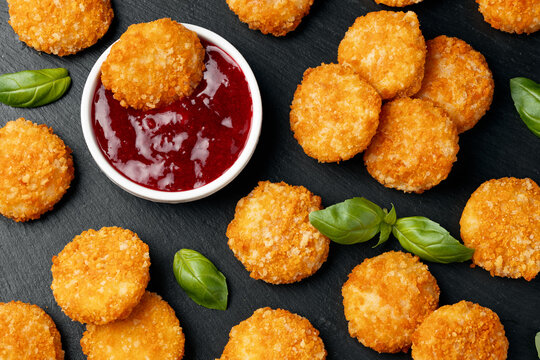 Fried breaded camembert cheese bites with berry sauce