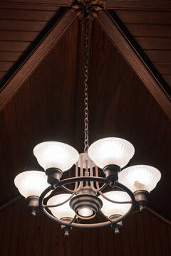 Looking up at a rustic iron and glass hanging chandelier light fixture
