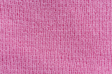 Soft pink knitted fabric texture with uniform rib pattern photographed as minimal abstract winter textile background
