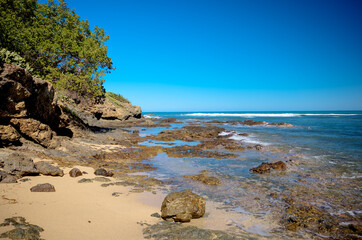 The grounds, pool and beach of the Senator Peurto Plata Hotel in the Dominican Republic, surrounded by palm trees under clear blue skies.
