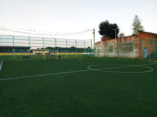 Soccer field with artificial turf and goalposts during sunset