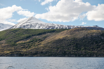 Obraz premium Nature scenery with fresh snow on the mountain and the forested hills towards the Beagle Channel in Ushuaia, Argentina