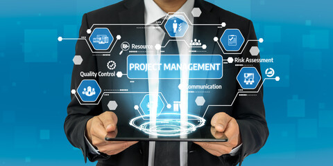 A business professional stands with a tablet displaying holographic project management icons. This image highlights concepts like communication, risk assessment, and quality control. Tessel