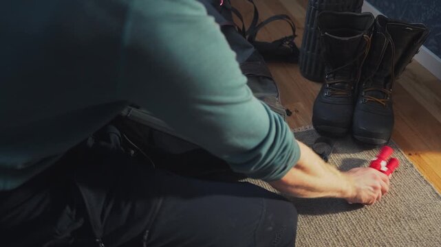 Packing ice picks into backpack at home, winter safety preparation