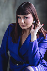 Elegant mature woman in a blue suit and tights. Gorgeous beautiful attractive plus size young woman with long hair. Body positive concept. Happy smiling single female