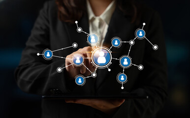 A business professional interacts with a digital network of people using a tablet, symbolizing connections and collaboration in a modern office setting. Tessel