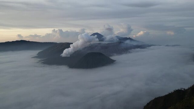 Mount Bromo, East Java, Indonesia - June 10, 2024: Dramatic plumes of volcanic gas rise from the active crater. Majestic sunrise views of the smoking caldera in Bromo Tengger Semeru National Park.