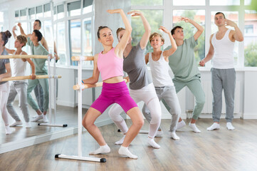 Fototapeta premium Ballet lesson for teenagers - choreographer teaches girls and boys ballet steps