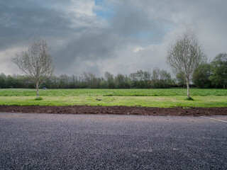 Renovation in a town park with layer of fresh soil to level up green field surface.