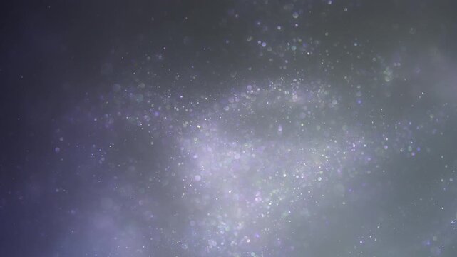 Shimmering purple and silver dust particles floating softly against a dark grey atmospheric background with bokeh effects
