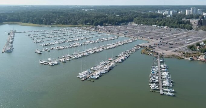Aerial view of Suomenoja Marina, featuring numerous sailboats and yachts docked along a piers in summer, Espoo, Finland.