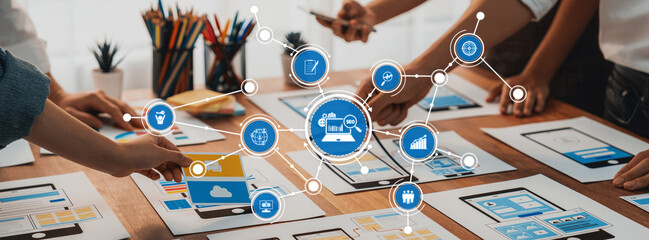 A dynamic workspace showcasing hands engaged in collaborative design, utilizing graphics and mobile application layouts on a table, fostering creativity and innovation. Amity