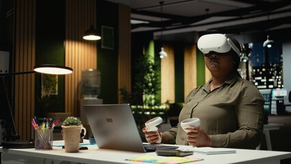 Young businesswoman using virtual reality headset and gadgets to draft a plan, forecasting projections and documenting risk assessment. Organizing tasks to align with business goals. Camera A.