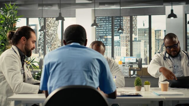 Diverse surgeons staff in a clinic discussing therapy options and research analysis. The meeting highlights professionalism and innovation in healthcare planning in hospital. - Powered by Adobe