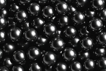 Close-up of shiny, dark spheres clustered together, reflecting light