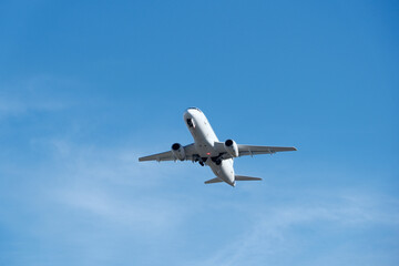Obraz premium White commercial airplane climbing in clear blue sky after takeoff. White plane climbing after takeoff against the blue sky