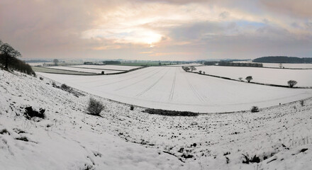 Sunset over snow covered fields in winter