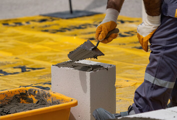 The bricklayer is working. Building a wall of aerated concrete. Gasbeton wall