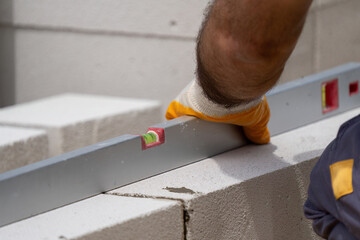 The bricklayer is working. Building a wall of aerated concrete. Gasbeton wall