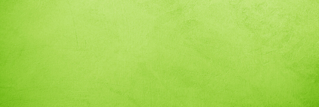 Bright light green yellow lime fresh chartreuse texture background. Painted concrete wall surface. Close-up. Grunge rough uneven scratch. Empty blank minimal template design ad. Wide banner.Panoramic.
