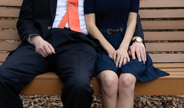 Couple sitting next to each other on bench in park