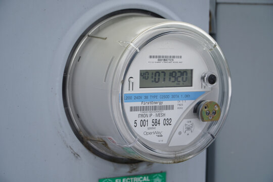 Digital smart electric meter mounted on an exterior wall of a building for residential energy monitoring and utility billing services.