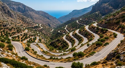 Winding Road Through Rugged Mountain Landscape to Distant Sea.