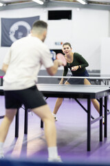 Fototapeta premium People playing competitive table tennis match indoors