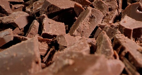Chunks Of Dark Cocoa Against Textured Surface, Fragmented Chocolate On Rough Background With Inviting Aroma