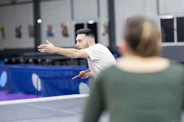 Man playing table tennis serving ping pong ball