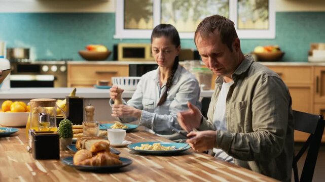 African american father interrupting breakfast meal to answer a phone call, neglecting his family and being busy at home. Working dad ignoring his tween daughter at the table. Camera B.