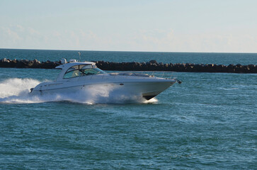 Upscale cabin cruiser speeding on Government Cut Inlet off of Miami Beach.