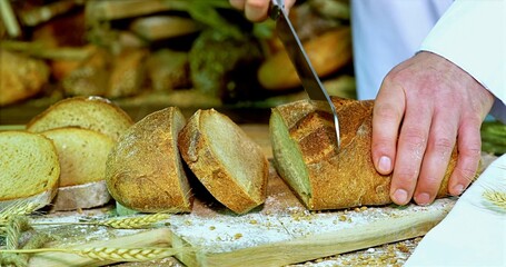 Bread Being Cut On Wooden Surface, Craftsman Slicing Crispy Bread With Knife On Textured Wooden Board
