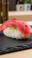 Delicious Tuna Nigiri Sushi on a Black Plate.