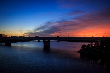 Fototapeta premium Dramatic Sunset Glow Over a Silhouetted City Bridge