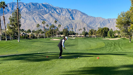 Obraz premium Woman Golfer Teeing Off on Palm Springs Golf Course
