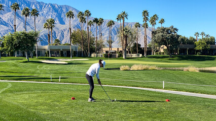 Obraz premium Woman Golfer Teeing Off on Palm Springs Golf Course