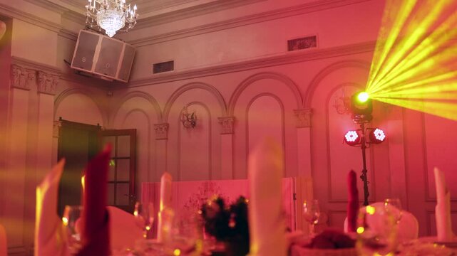 Yellow Beam Light Flooding Banquet Tables in the Hall