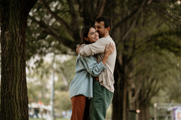 Happy couple embracing in park, expressing love and affection