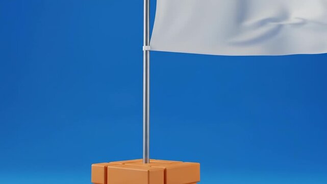Blank white flag waving on a l pole, standing on a brick base against blue sky.