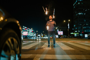 Man fire juggling on city street at night