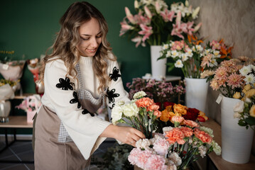 Woman florist arranging flowers in small business shop